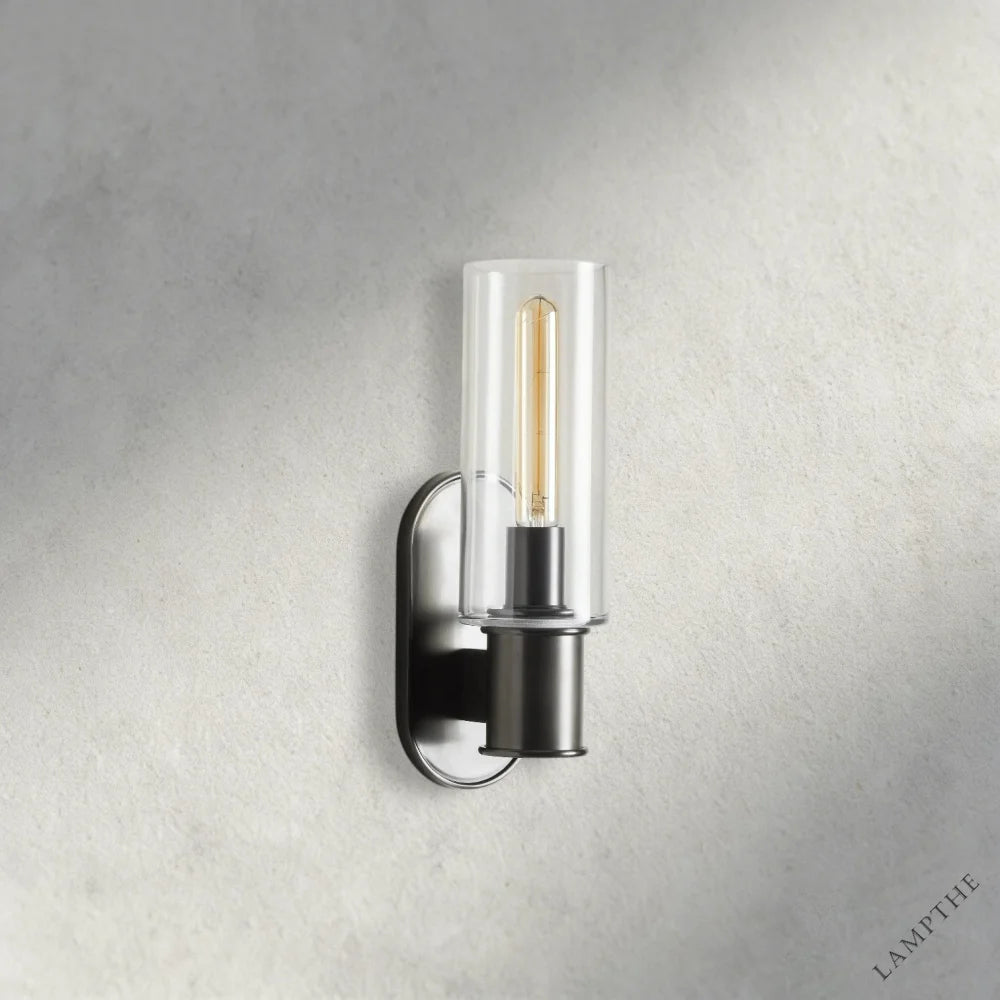 Lampthe Harlin Sconce with clear glass shade and black metal base, featuring an Edison bulb.