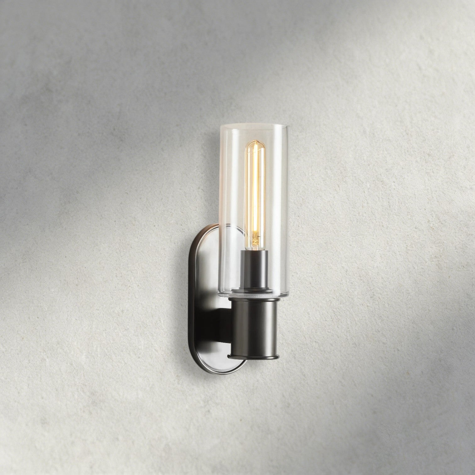 Lampthe Harlin Sconce in clear glass with a dark metal base and exposed Edison bulb, featuring modern sophistication.