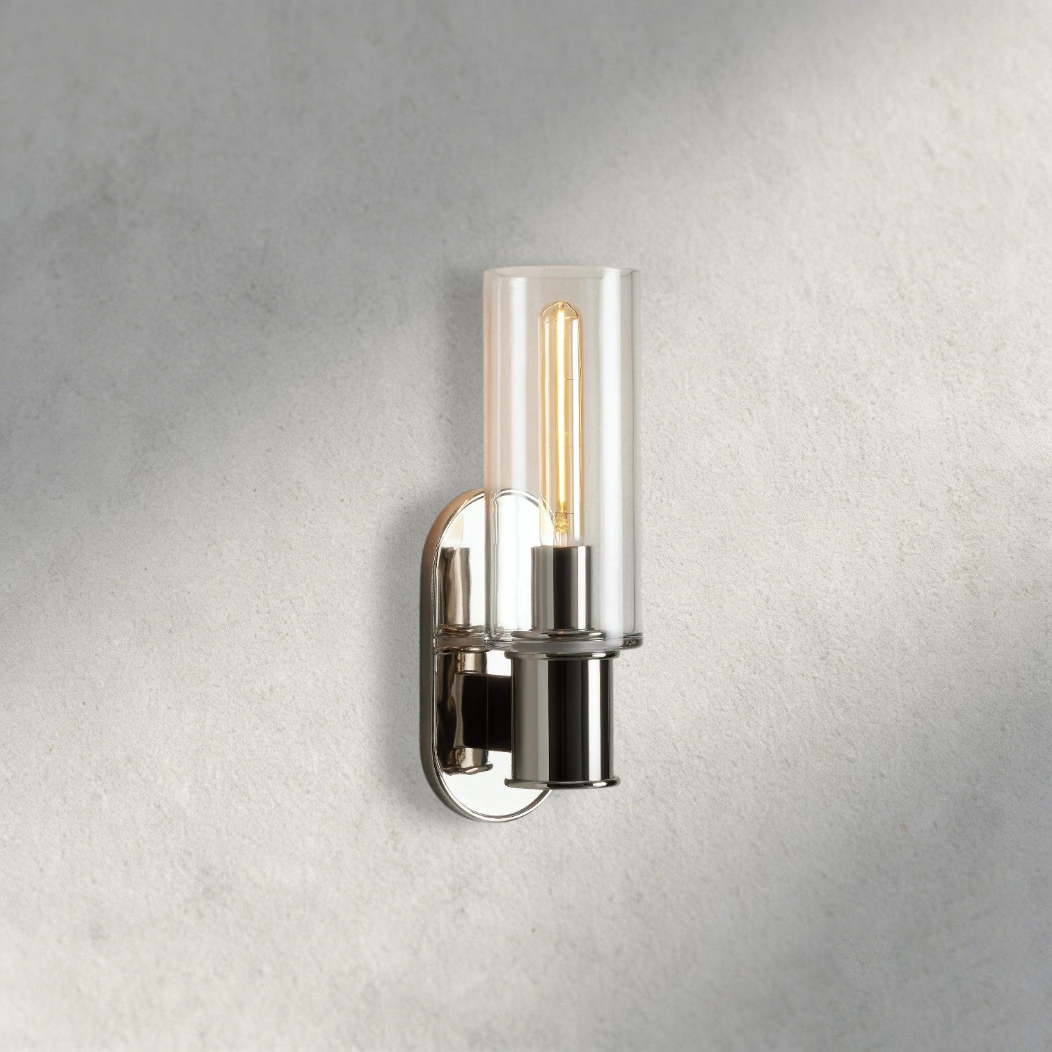 Lampthe Harlin Sconce features a clear glass cylinder shade and a polished nickel finish with an exposed Edison bulb.