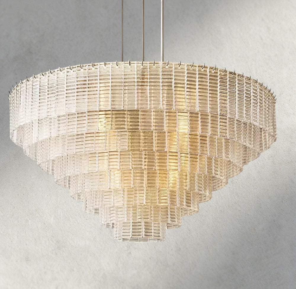 Lampthe Sirene clear glass round chandelier with textured cast glass cascading in concentric rings, refracting warm light.