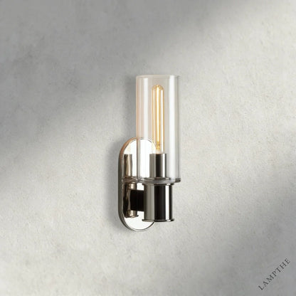Lampthe Harlin Sconce features a clear glass cylinder shade and a polished nickel finish with an exposed Edison bulb.