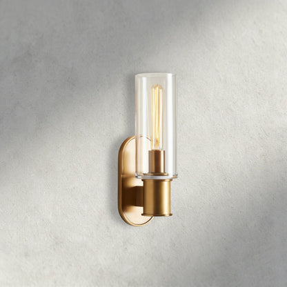 Lampthe Harlin sconce with clear glass shade and brass finish. Modern wall light with arched backplate.