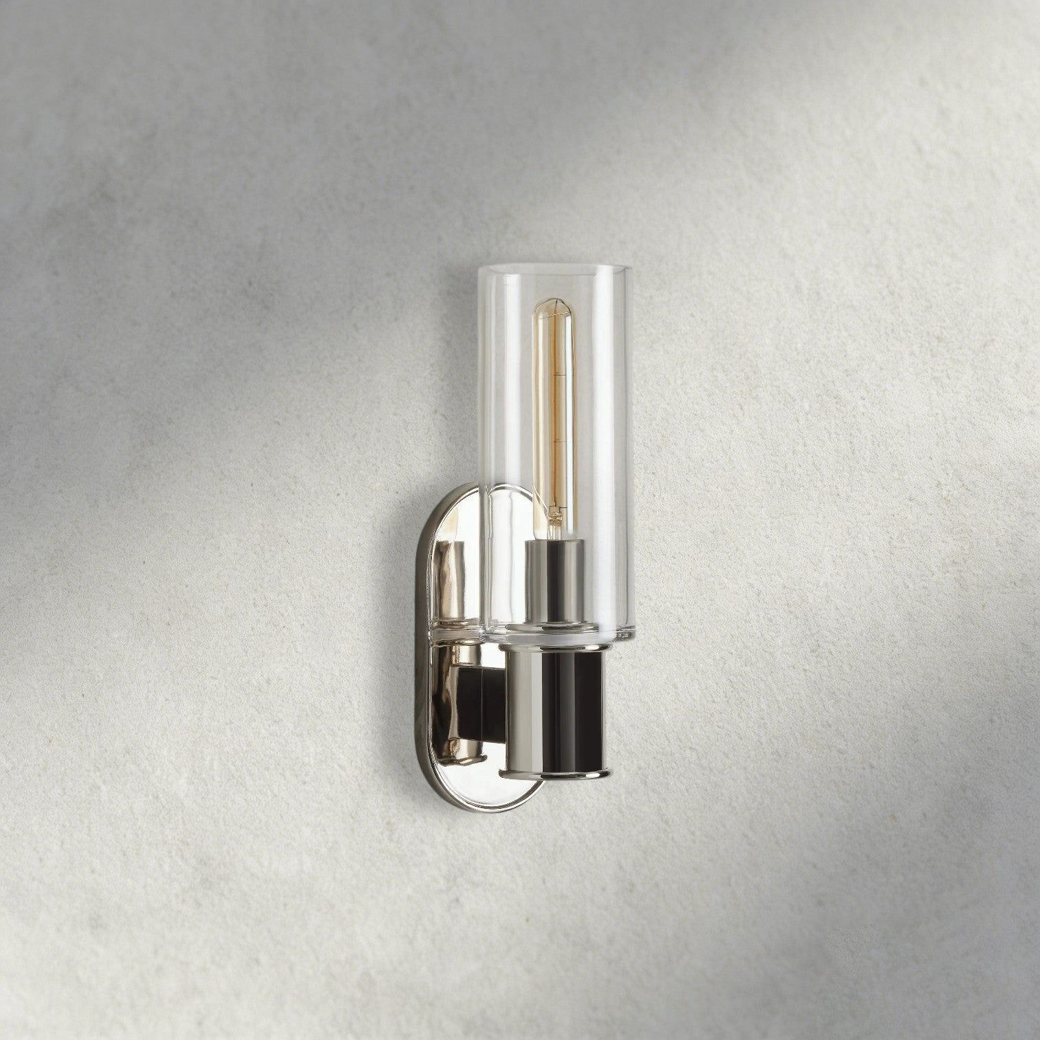 Lampthe Harlin Sconce: clear glass shade, polished nickel finish, and exposed Edison bulb. Modern sophistication.