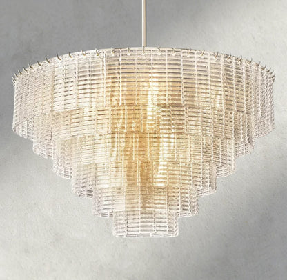 Lampthe Sirene clear glass tiered chandelier with textured cast glass cascading in concentric rings, emitting warm refracted light.