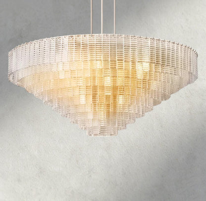 Lampthe Sirene clear glass round chandelier with textured glass cascading in concentric rings, emitting warm refracted light.