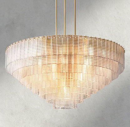 Lampthe Sirene clear glass round chandelier with concentric rings of textured glass and brass accents, casting warm refracted light.