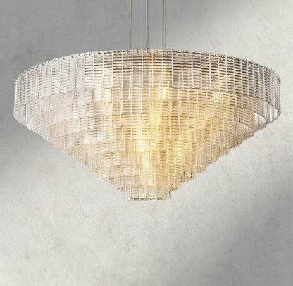 Lampthe Sirene clear glass round chandelier with textured glass cascading in concentric rings, emitting warm refracted light.