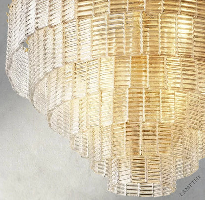 Lampthe Sirene clear glass round chandelier with textured glass cascading in concentric rings, refracting warm light.
