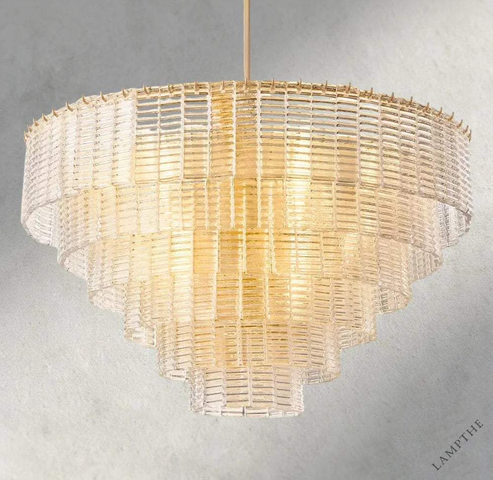 Lampthe Sirene clear glass round chandelier with textured cast glass cascading in concentric rings, emitting warm refracted light.
