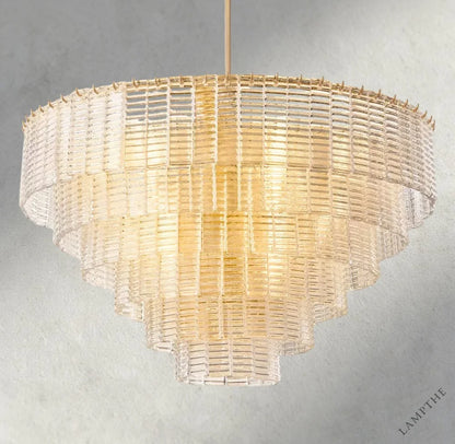Lampthe Sirene clear glass round chandelier with textured cast glass cascading in concentric rings, emitting warm refracted light.